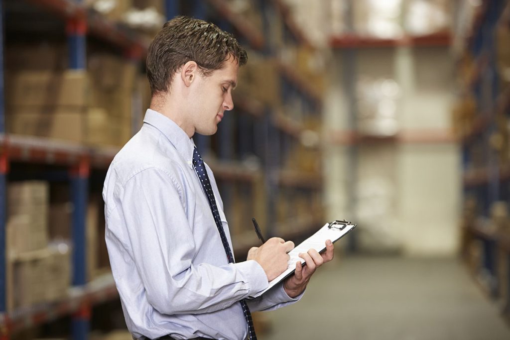 Homem realizando anotações em prancheta
