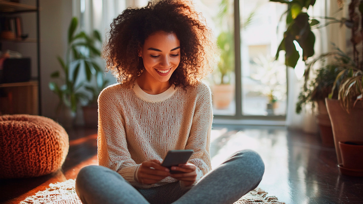 Mulher afro descendente com celular na mão