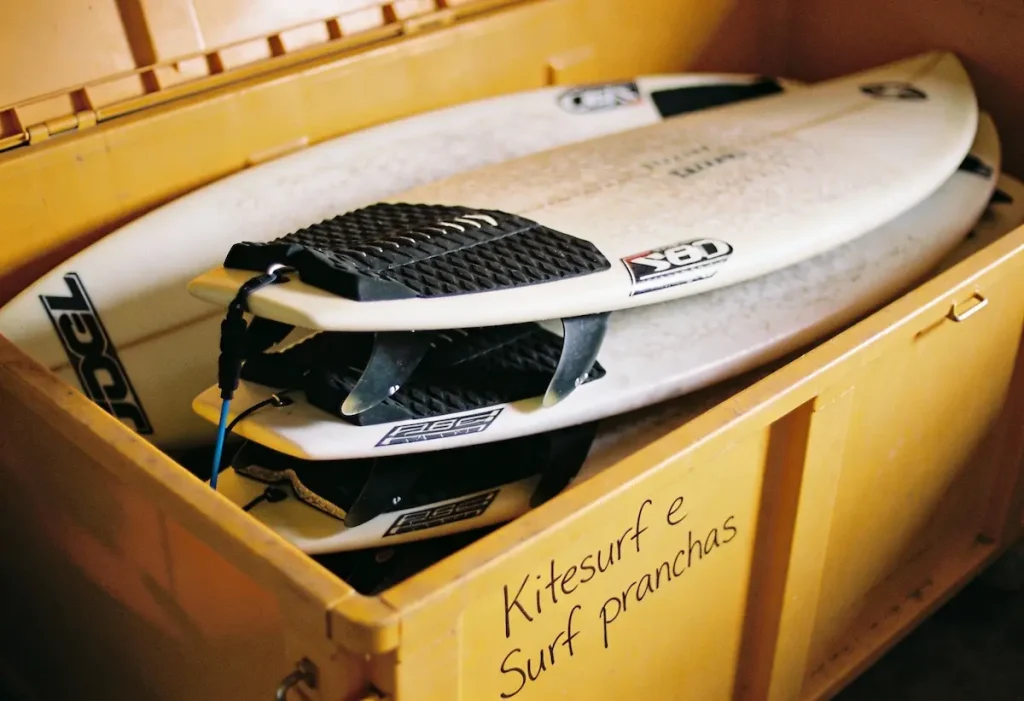 Interior de um box de self storage da Guardeaju limpo e organizado, contendo pranchas de surf em suportes verticais e equipamentos de kitesurf armazenados com segurança contra a maresia em Aracaju.