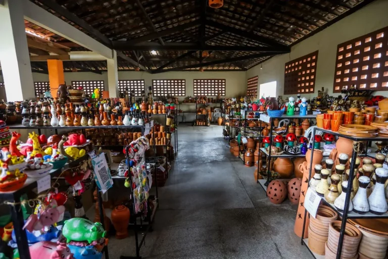 Loja de artesanato em Santana do São Francisco com grande variedade de cerâmicas artesanais, esculturas decorativas e objetos feitos à mão expostos em prateleiras.