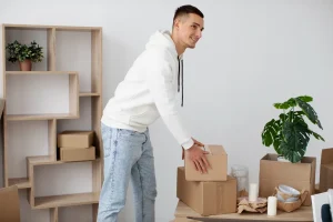 Pessoa organizando móveis e caixas em um box limpo de self storage